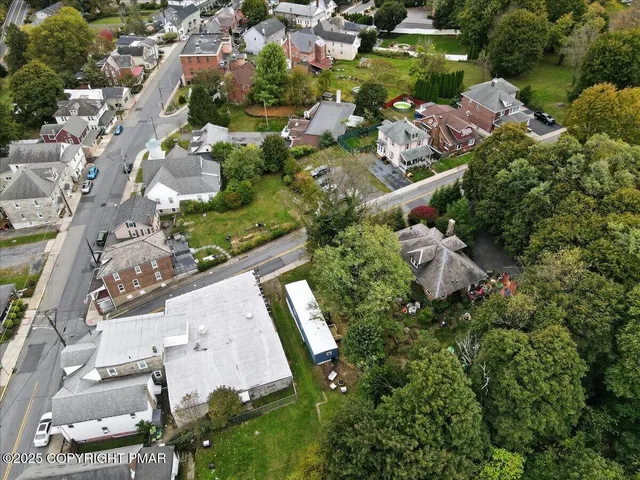 an aerial view of residential houses with outdoor space and street view