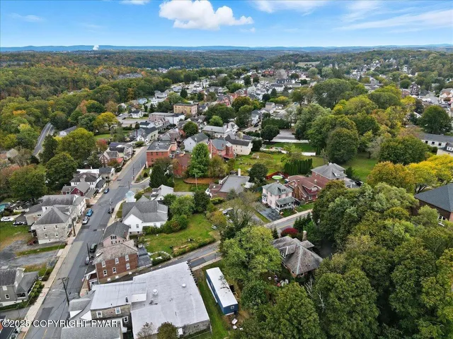 an aerial view of residential houses with outdoor space and trees