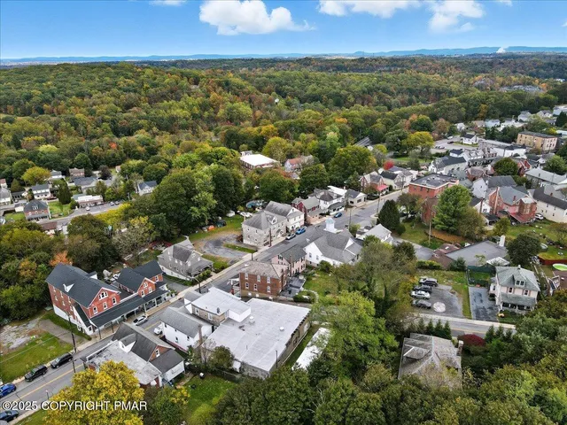 an aerial view of residential houses with outdoor space and trees