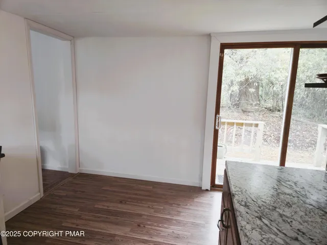 a view of a room with wooden floor and a window