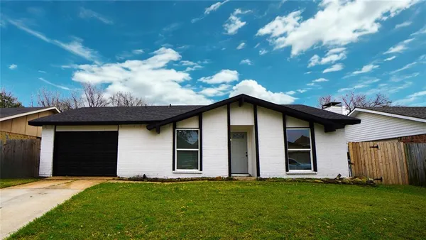 a house that has a big yard with wooden fence