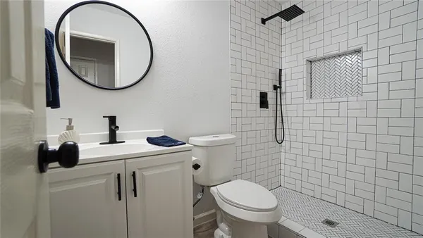 a bathroom with a toilet a sink and a mirror