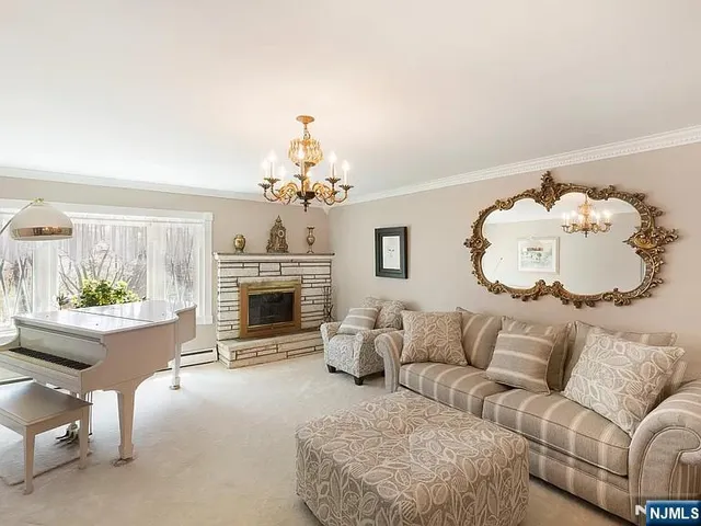 a living room with furniture a fireplace and a chandelier
