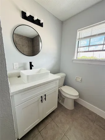 a bathroom with a toilet a sink and mirror