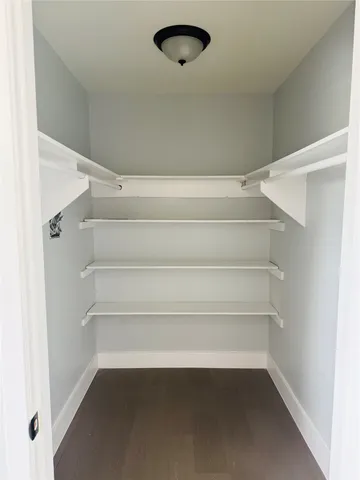 a view of walk in closet with empty racks