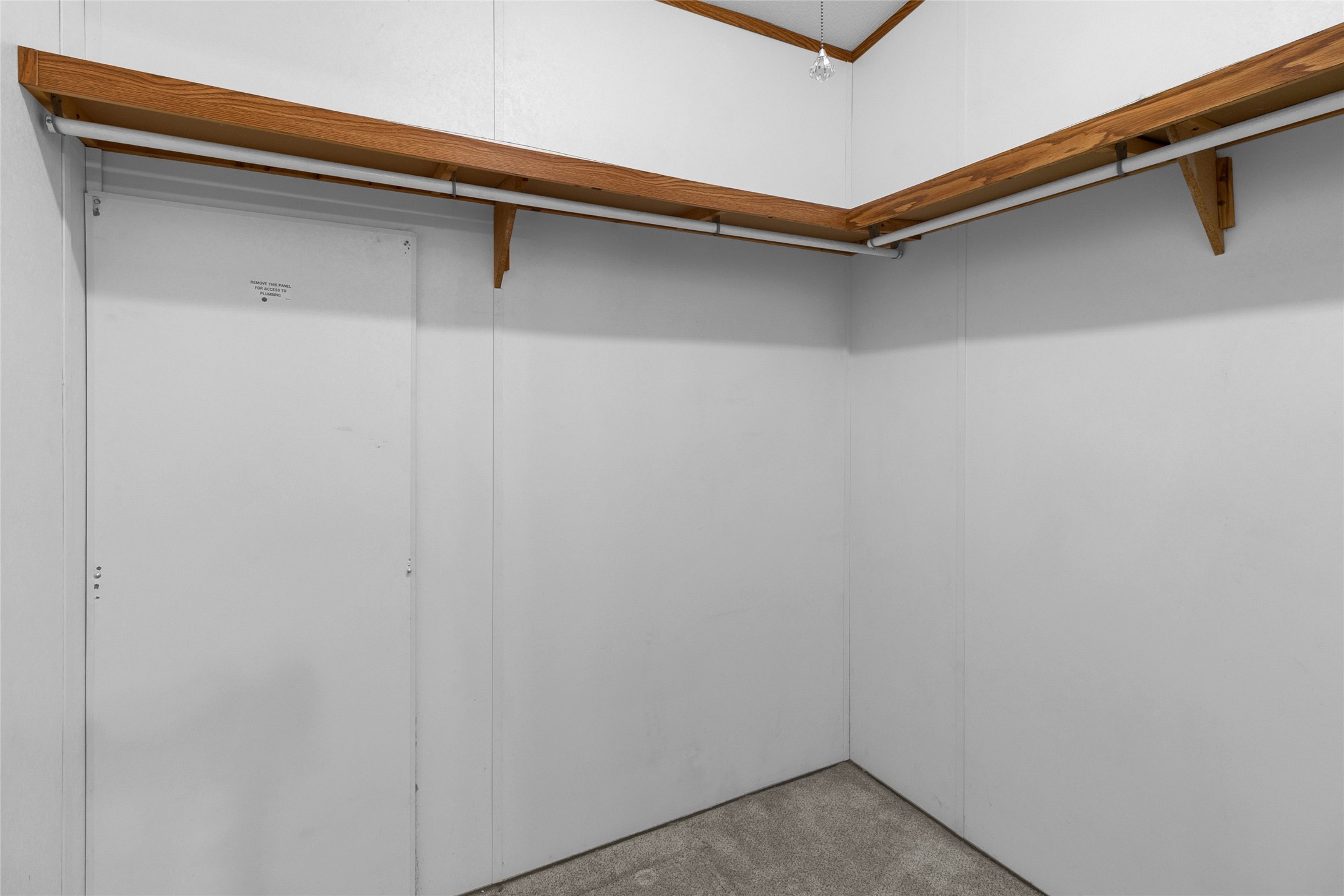 22094 Spear Road Porter, TX 77365 - Photo 26 of 45 Primary spacious walk-in closet with white walls, featuring wooden shelves and hanging rods, perfect for organizing clothing and accessories.