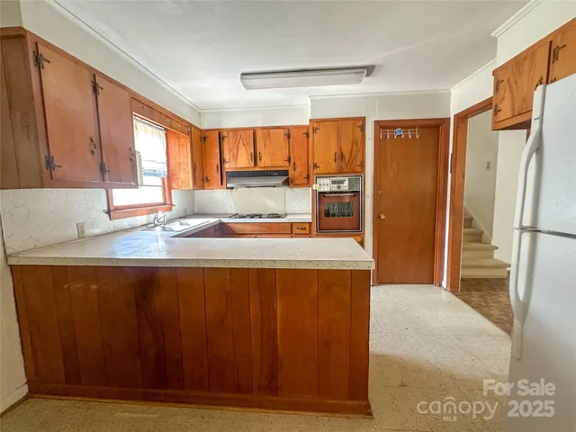 a kitchen with stainless steel appliances granite countertop a refrigerator and a sink