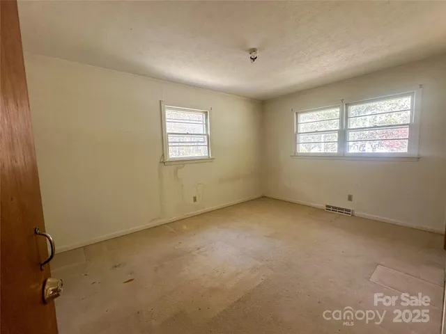 an empty room with a empty space and windows