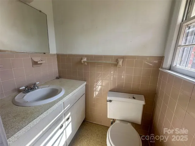 a bathroom with a sink toilet and a mirror