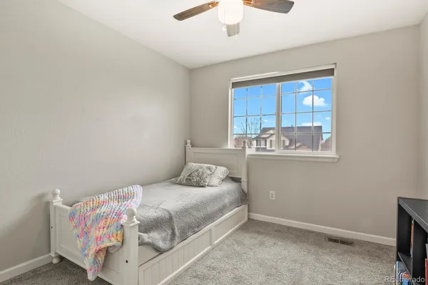 a bedroom with a bed and a chandelier fan