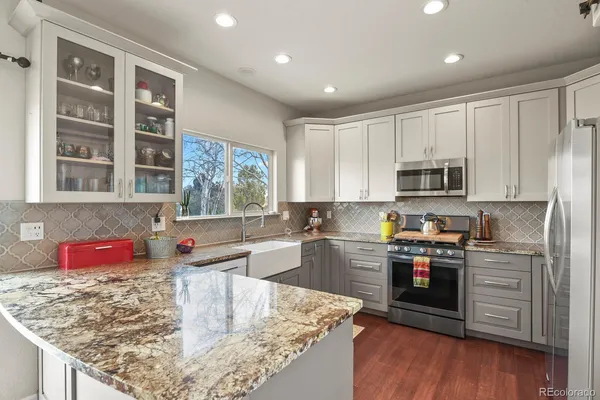 a kitchen with stainless steel appliances granite countertop a sink stove and wooden cabinets