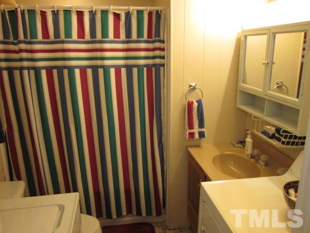 285 Kerr Lake Road Henderson, NC 27537 - Photo 21 of 25 a bathroom with a sink a toilet and a mirror