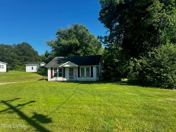 a front view of a house with yard and green space