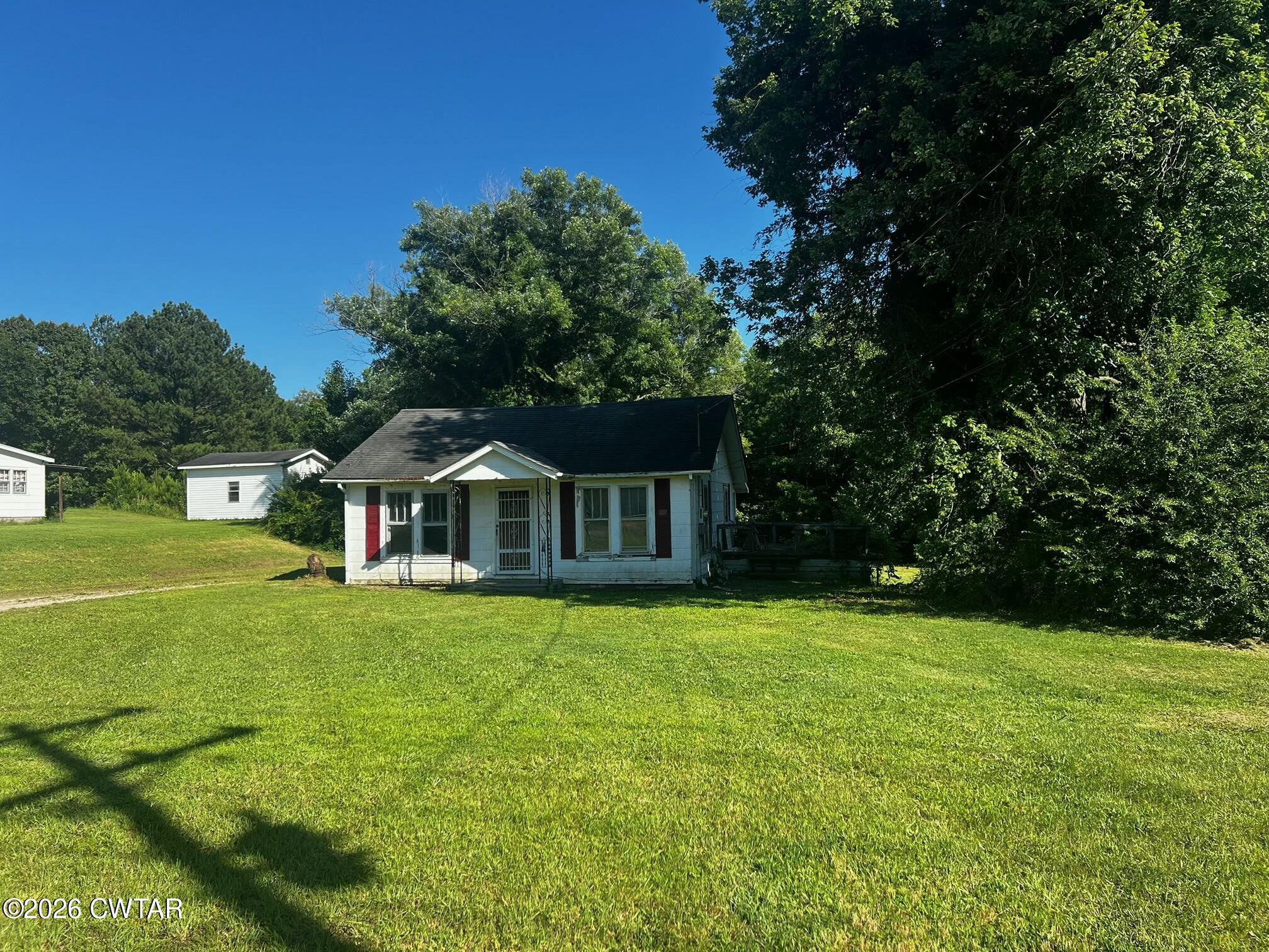 a front view of a house with yard and green space
