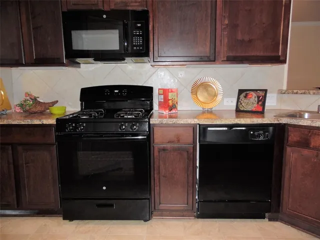 a kitchen with stainless steel appliances granite countertop a stove and a microwave