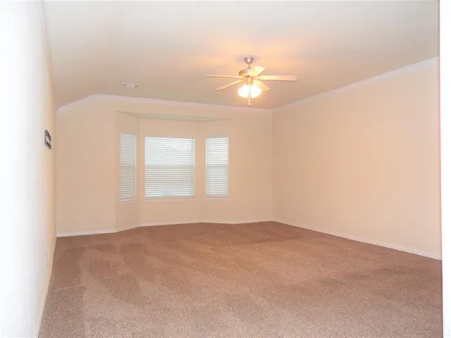 an empty room with a ceiling fan and a window