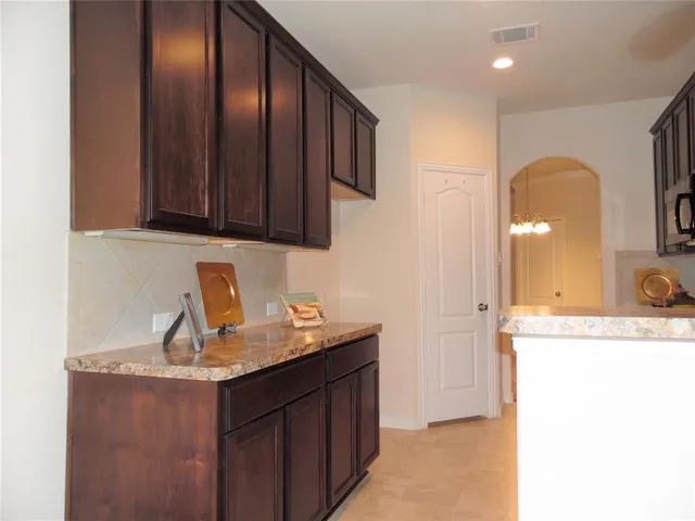 a kitchen with granite countertop a sink a stove and cabinets