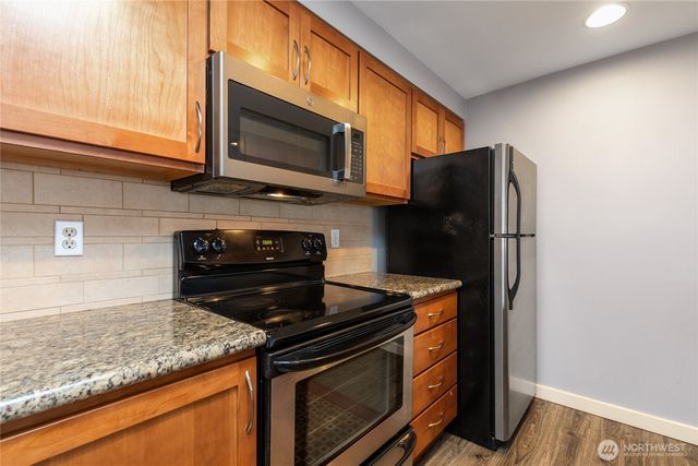 a kitchen with stainless steel appliances granite countertop a stove microwave and refrigerator