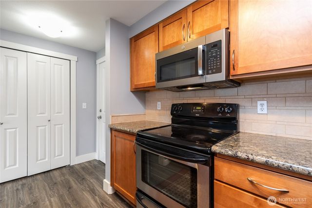 a kitchen with stainless steel appliances granite countertop a stove microwave and oven