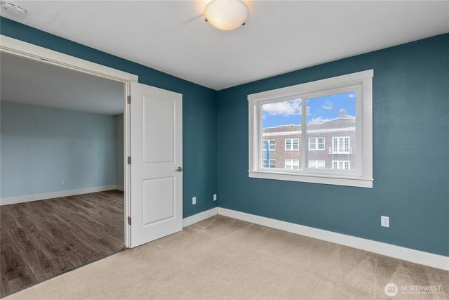 a view of an empty room with window and closet area