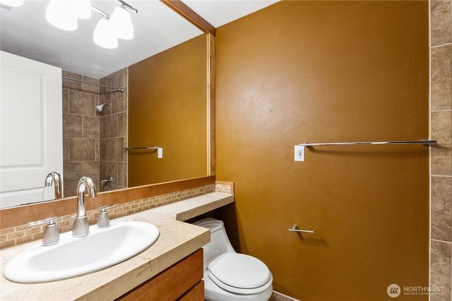 a bathroom with a sink mirror vanity and toilet