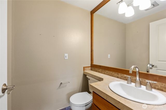 a bathroom with a toilet a sink and mirror