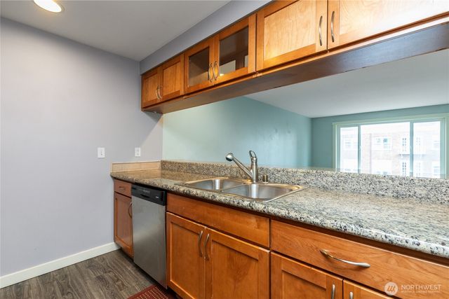 a kitchen with stainless steel appliances granite countertop a sink and a wooden cabinets