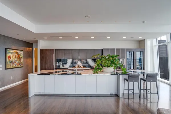 a kitchen with stainless steel appliances kitchen island granite countertop a dining table chairs and granite counter tops