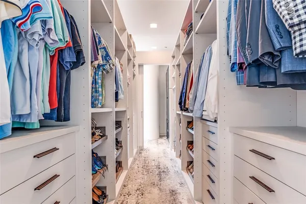 a view of walk in closet with clothes and shoes