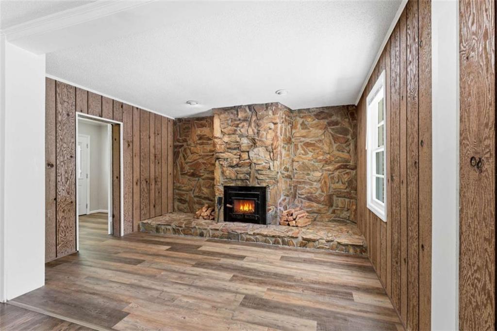 229 Hilltop Lane Toccoa, GA 30577 - Photo 5 of 30 a view of an empty room with wooden floor fireplace and a window