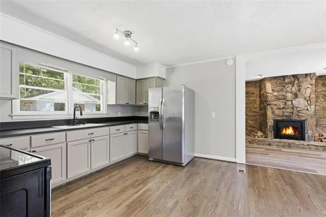 a kitchen with stainless steel appliances granite countertop a stove a sink and a refrigerator