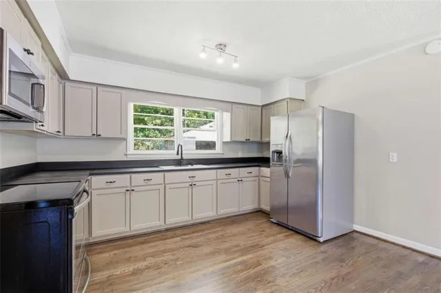 a kitchen with stainless steel appliances granite countertop a stove a sink and a refrigerator
