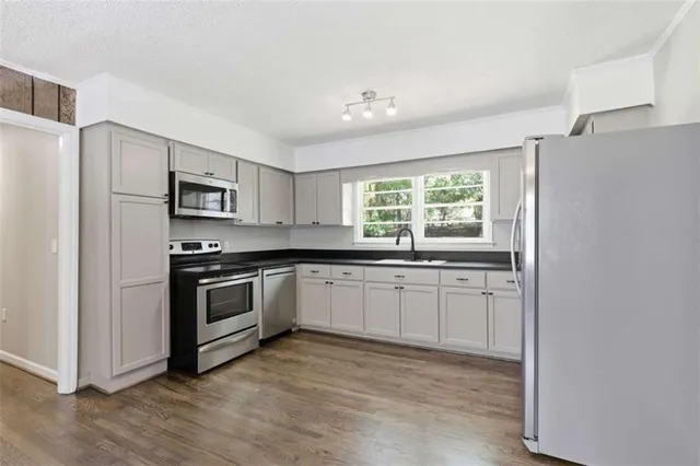 a kitchen with stainless steel appliances granite countertop a stove a sink and a refrigerator
