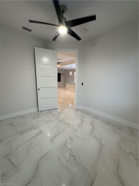 2963 18th Avenue Northeast Naples, FL 34120 - Photo 4 of 10 Empty room featuring light marble finish flooring and ceiling fan