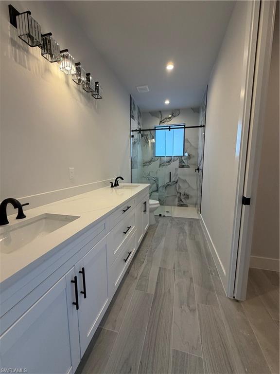 2963 18th Avenue Northeast Naples, FL 34120 - Photo 9 of 10 Bathroom featuring double vanity, a marble finish shower, and recessed lighting