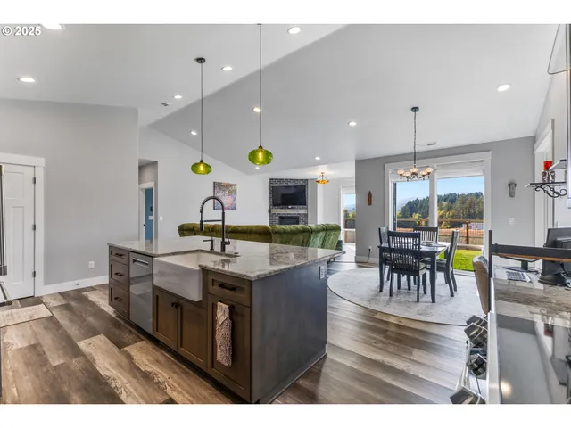 a kitchen with stainless steel appliances kitchen island a stove a table and chairs