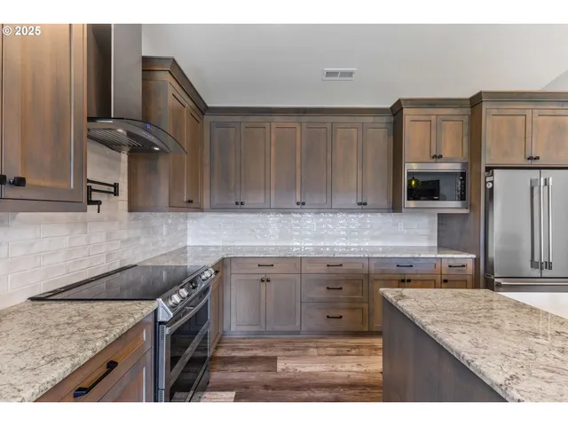 a kitchen with granite countertop a sink stove and refrigerator