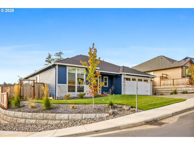 a front view of a house with a yard and potted plants