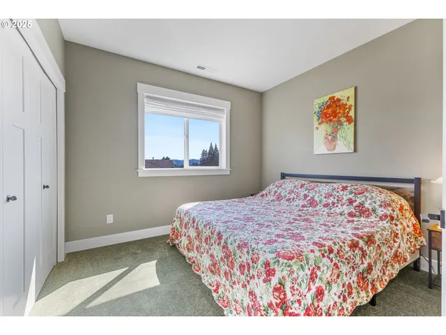 a bedroom with a bed and a painting on the wall