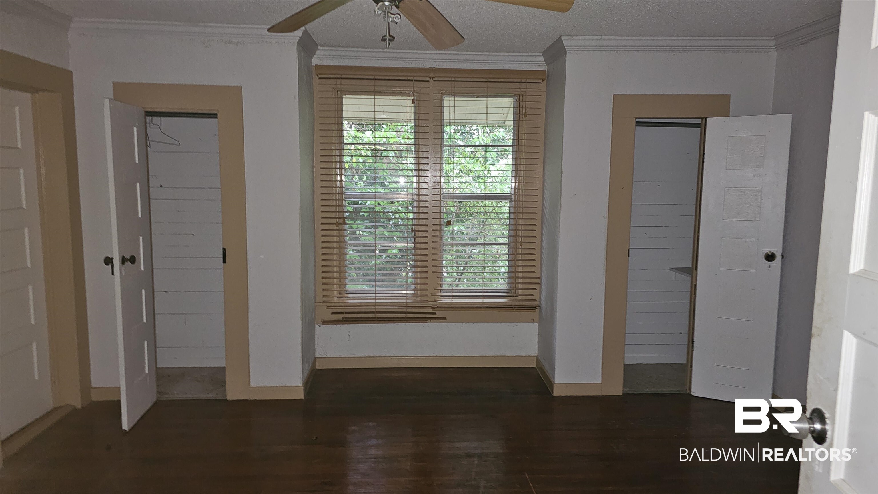 307 Scott Street Brewton, AL 36426 - Photo 12 of 19 Unfurnished bedroom featuring ceiling fan, dark hardwood / wood-style floors, crown molding, and a textured ceiling