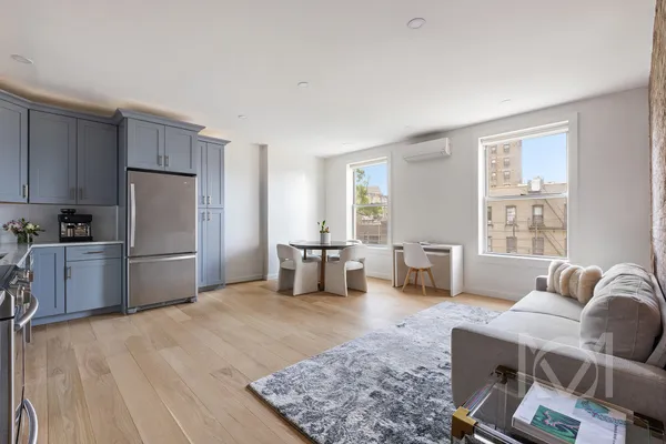 a kitchen with stainless steel appliances wooden floor and a refrigerator