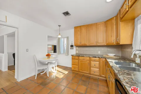 a kitchen with a sink and chairs