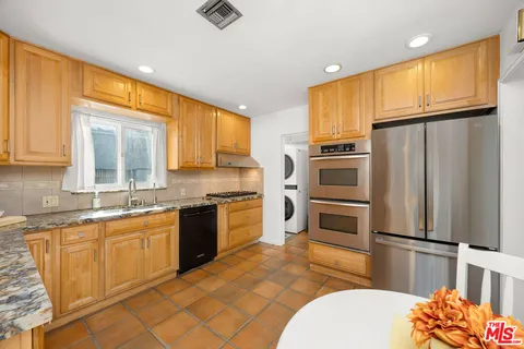 a kitchen with stainless steel appliances a refrigerator sink and cabinets