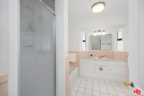 a spacious bathroom with a mirror sink and mirror