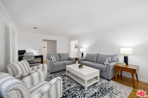 a living room with furniture a rug and a lamp