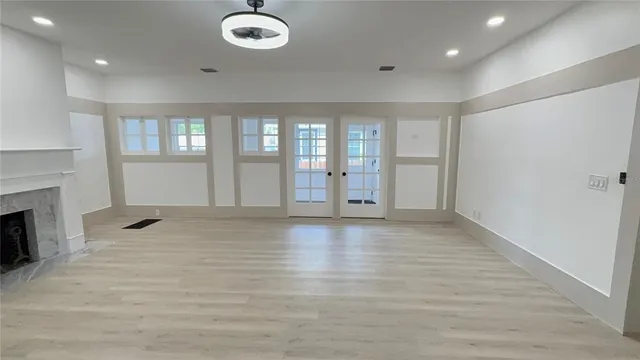 an empty room with wooden floor and fireplace