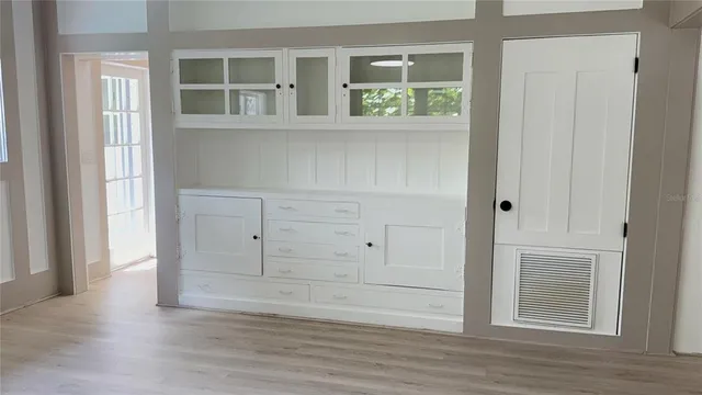 a view of empty room with wooden floor and cabinet