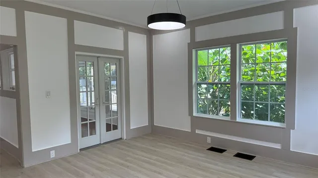 a view of an empty room with a window and wooden floor