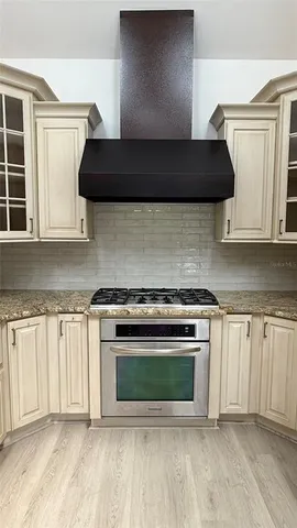 a kitchen with stainless steel appliances granite countertop a stove a sink and a microwave