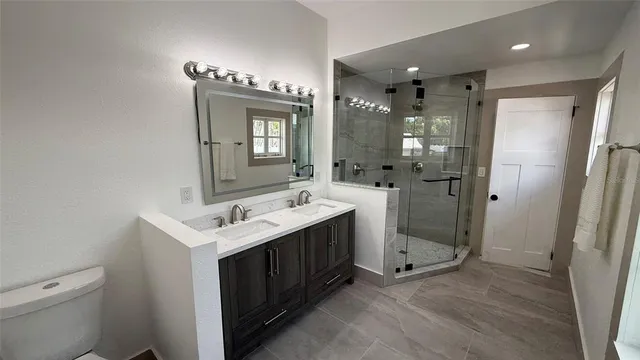 a bathroom with a double vanity sink mirror and toilet